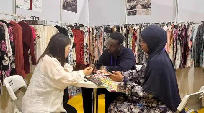 Our salesman, Xiao Zhang, negotiated with two foreign buyers about the headscarf fabric business.